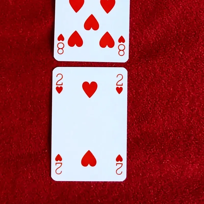 Playing cards laid out in rows on red felt