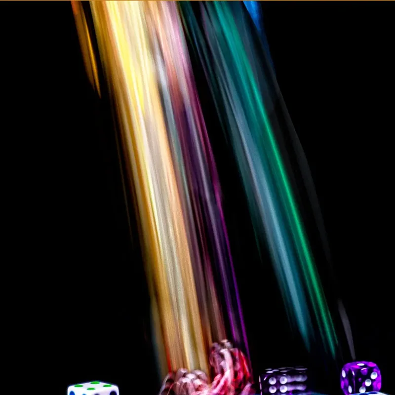 Colourful dice tumbling in streaks of light on a dark background